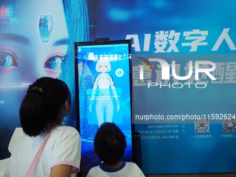 A child talks with an AI digital human at the 2024 National Science Popularization Day in Beijing, China, on September 21, 2024. (