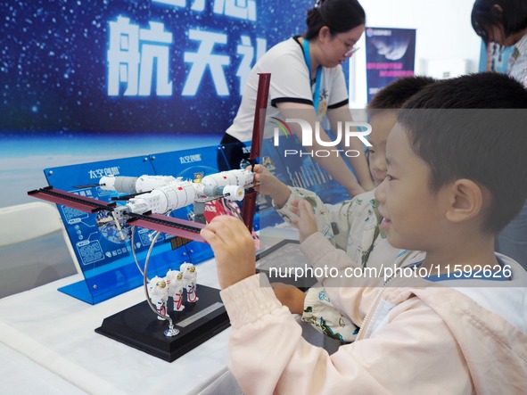 A child experiences a model of the ''Tiangong Space Station'' during the 2024 National Science Popularization Day in Beijing, China, on Sept...