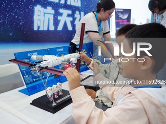 A child experiences a model of the ''Tiangong Space Station'' during the 2024 National Science Popularization Day in Beijing, China, on Sept...