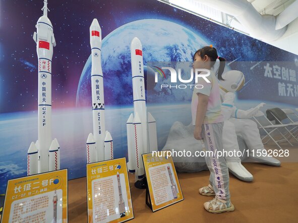 A child looks at a model of the Long March rocket during the 2024 National Science Popularization Day in Beijing, China, on September 21, 20...