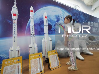 A child looks at a model of the Long March rocket during the 2024 National Science Popularization Day in Beijing, China, on September 21, 20...