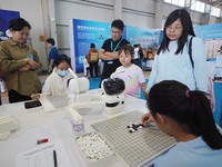 A child plays Weiqi with a robot during the 2024 National Science Popularization Day in Beijing, China, on September 21, 2024. (