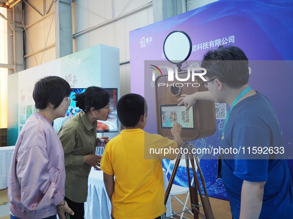 A child takes an AI photo during the 2024 National Science Popularization Day in Beijing, China, on September 21, 2024. 