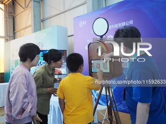 A child takes an AI photo during the 2024 National Science Popularization Day in Beijing, China, on September 21, 2024. (