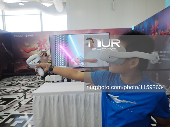 A child experiences a ''VR game'' during the 2024 National Science Popularization Day in Beijing, China, on September 21, 2024. 