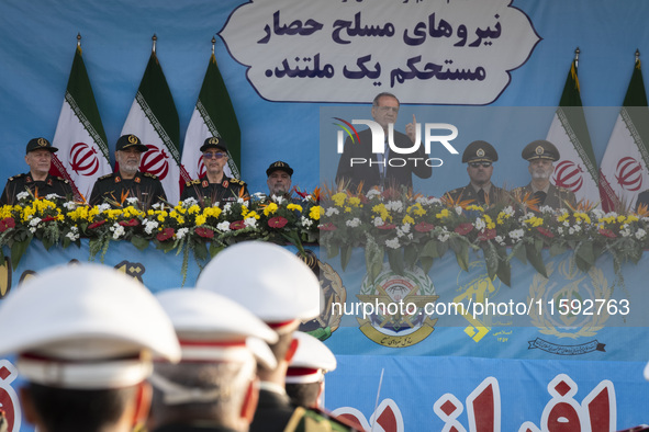 Iranian President Masoud Pezeshkian (C) speaks while standing next to Iranian army and IRGC commanders during a military parade commemoratin...