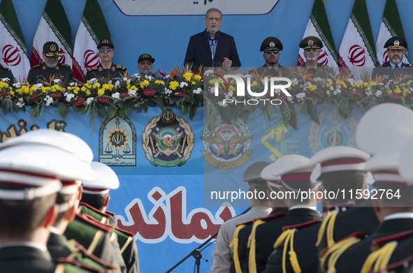 Iranian President Masoud Pezeshkian (C) speaks while standing next to Iranian army and IRGC commanders during a military parade commemoratin...