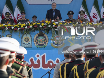 Iranian President Masoud Pezeshkian (C) speaks while standing next to Iranian army and IRGC commanders during a military parade commemoratin...