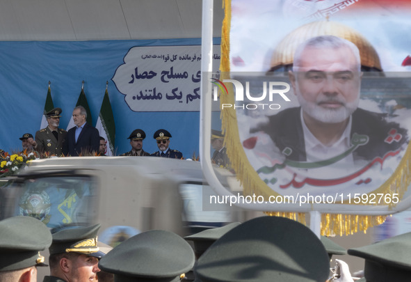 Commander-in-Chief of the Islamic Republic of Iran Army, Abdolrahim Mousavi, speaks with Iranian President Masoud Pezeshkian, while a flag f...