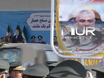 Commander-in-Chief of the Islamic Republic of Iran Army, Abdolrahim Mousavi, speaks with Iranian President Masoud Pezeshkian, while a flag f...