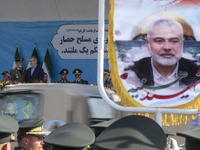 Commander-in-Chief of the Islamic Republic of Iran Army, Abdolrahim Mousavi, speaks with Iranian President Masoud Pezeshkian, while a flag f...