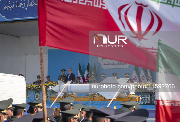 Commander-in-Chief of the Islamic Republic of Iran Army, Abdolrahim Mousavi, and Iranian President Masoud Pezeshkian look at a missile carri...