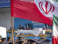 Commander-in-Chief of the Islamic Republic of Iran Army, Abdolrahim Mousavi, and Iranian President Masoud Pezeshkian look at a missile carri...