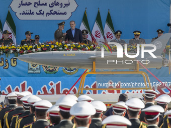 Commander-in-Chief of the Islamic Republic of Iran Army, Abdolrahim Mousavi, speaks with Iranian President Masoud Pezeshkian, while an Irani...