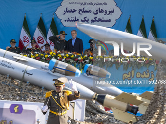 Islamic Revolutionary Guard Corps aerospace division commander General Amir Ali Hajizadeh speaks with Iranian President Masoud Pezeshkian, w...