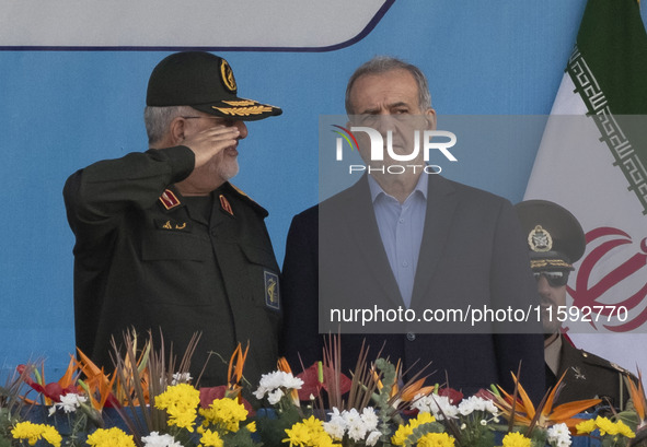 Commander of the Islamic Revolutionary Guard Corps' Ground Force, General Mohammad Pakpour (L), salutes while speaking with Iranian Presiden...