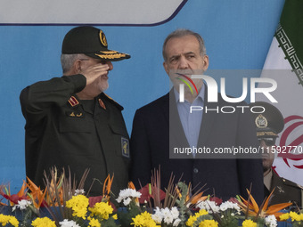 Commander of the Islamic Revolutionary Guard Corps' Ground Force, General Mohammad Pakpour (L), salutes while speaking with Iranian Presiden...