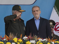 Commander of the Islamic Revolutionary Guard Corps' Ground Force, General Mohammad Pakpour (L), salutes while speaking with Iranian Presiden...