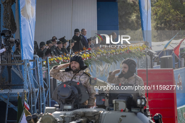 Commander of the Islamic Revolutionary Guard Corps' Ground Force, General Mohammad Pakpour (center L), salutes while speaking with Iranian P...