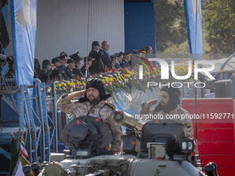 Commander of the Islamic Revolutionary Guard Corps' Ground Force, General Mohammad Pakpour (center L), salutes while speaking with Iranian P...