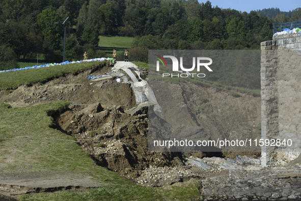 Firefighters inspect the damaged embankment of the Stronie Slaskie dam on the Morawka river in Stronie Slaskie, Poland on September 21, 2024...