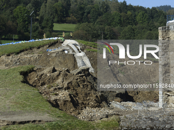 Firefighters inspect the damaged embankment of the Stronie Slaskie dam on the Morawka river in Stronie Slaskie, Poland on September 21, 2024...