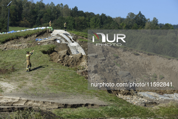 Firefighters inspect the damaged embankment of the Stronie Slaskie dam on the Morawka river in Stronie Slaskie, Poland on September 21, 2024...