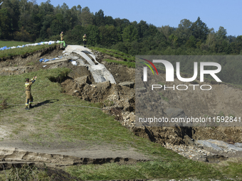 Firefighters inspect the damaged embankment of the Stronie Slaskie dam on the Morawka river in Stronie Slaskie, Poland on September 21, 2024...