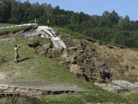 Firefighters inspect the damaged embankment of the Stronie Slaskie dam on the Morawka river in Stronie Slaskie, Poland on September 21, 2024...