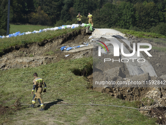 Firefighters inspect the damaged embankment of the Stronie Slaskie dam on the Morawka river in Stronie Slaskie, Poland on September 21, 2024...