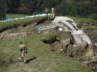 Firefighters inspect the damaged embankment of the Stronie Slaskie dam on the Morawka river in Stronie Slaskie, Poland on September 21, 2024...