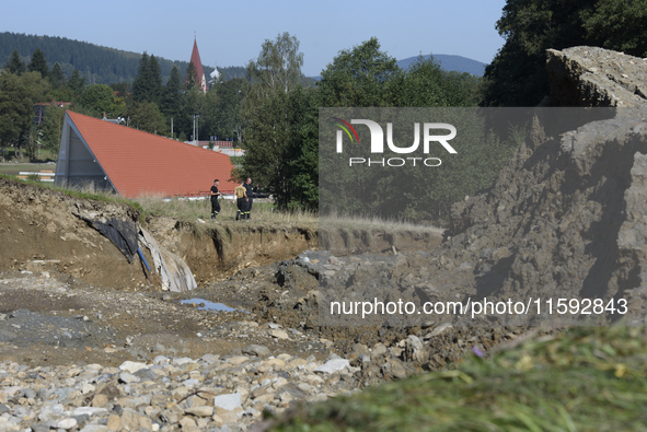 Firefighters inspect the damaged embankment of the Stronie Slaskie dam on the Morawka river in Stronie Slaskie, Poland on September 21, 2024...