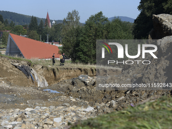 Firefighters inspect the damaged embankment of the Stronie Slaskie dam on the Morawka river in Stronie Slaskie, Poland on September 21, 2024...