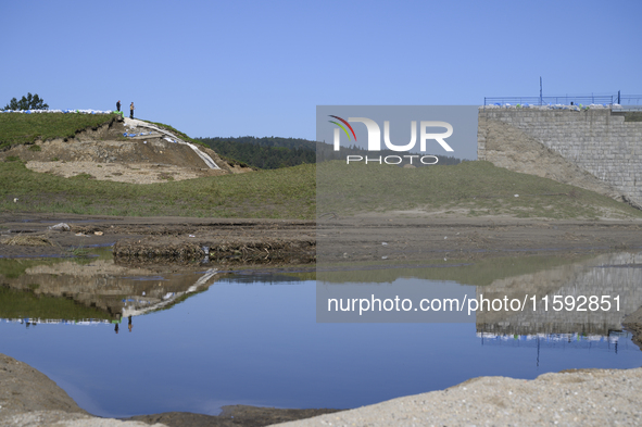 Firefighters inspect the damaged embankment of the Stronie Slaskie dam on the Morawka river in Stronie Slaskie, Poland on September 21, 2024...