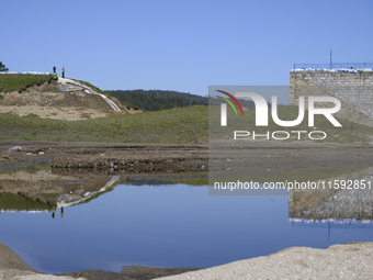 Firefighters inspect the damaged embankment of the Stronie Slaskie dam on the Morawka river in Stronie Slaskie, Poland on September 21, 2024...