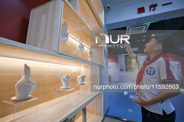 A child learns sign language at the Sign Language Museum at Nanjing School for the Deaf in Nanjing, China, on September 21, 2024. 