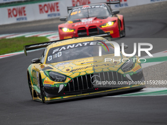 Maro Engel, Daniel Morad, and Lucas Auer of the Mercedes-AMG Team MANN-Filter stand next to a Mercedes-AMG GT3 EVO GT car on a pit lane duri...