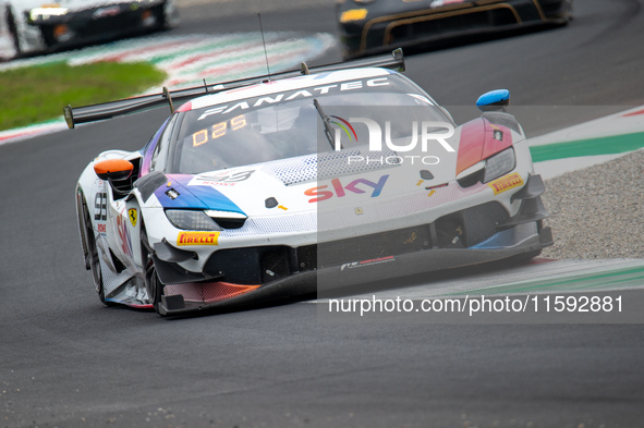 Eddie Cheever, Jonathan Hui, and Christopher Froggatt of team Sky Tempesta Racing stand by a Ferrari 296 GT3 GT car on a pit lane during the...