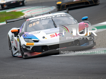 Eddie Cheever, Jonathan Hui, and Christopher Froggatt of team Sky Tempesta Racing stand by a Ferrari 296 GT3 GT car on a pit lane during the...