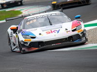 Eddie Cheever, Jonathan Hui, and Christopher Froggatt of team Sky Tempesta Racing stand by a Ferrari 296 GT3 GT car on a pit lane during the...