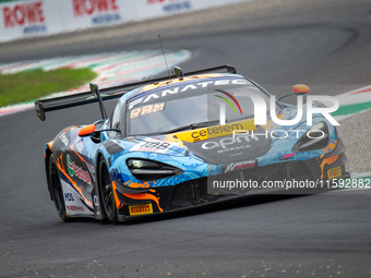 Adam Smalley, Miguel Ramos, and Louis Prette of team Garage 59 stand next to a McLaren 720S GT3 EVO GT car on a pit lane during the Fanatec...