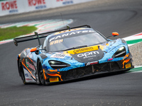 Adam Smalley, Miguel Ramos, and Louis Prette of team Garage 59 stand next to a McLaren 720S GT3 EVO GT car on a pit lane during the Fanatec...