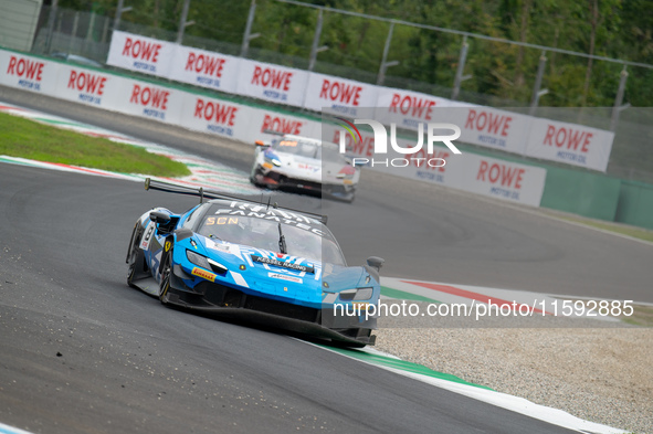 Nicolo Rosi, Niccolo Schiro, and David Fumanelli of team Kessel Racing stand next to a Ferrari 296 GT3 GT car on a pit lane during the Fanat...