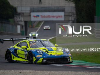 Dennis Marschall, Alexander Fach, and Dustin Blattner of the Rutronik Racing team stand next to a Porsche 911 GT3 R (992) GT car on a pit la...