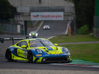 Dennis Marschall, Alexander Fach, and Dustin Blattner of the Rutronik Racing team stand next to a Porsche 911 GT3 R (992) GT car on a pit la...