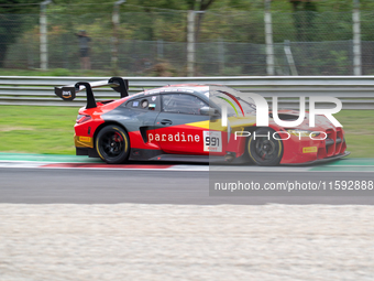 Christopher Haase, Alex Aka, and Ricardo Feller of Team Tresor Attempto Racing stand by an Audi R8 LMS GT3 EVO II GT car on a pit lane durin...