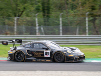 Ralf Bohn, Morris Schuring, and Robert Renauer of team Herberth Motorsport stand next to a Porsche 911 GT3 R (992) GT car on a pit lane duri...