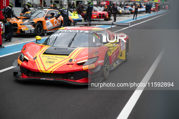 Alessio Rovera, Davide Rigon, and Alessandro Pier Guidi of team AF Corse - Francorchamps Motors stand by a Ferrari 296 GT3 GT car on a pit l...