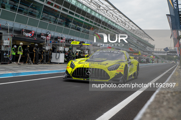 Luca Stolz, Fabian Schiller, and Jules Gounon of the M-AMG Team GetSpeed stand next to a Mercedes-AMG GT3 EVO GT car on a pit lane during th...