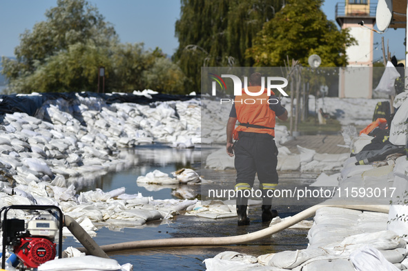 A firefighter walks on the flood barrier on the bank of the Danube in Vac, Hungary, about 42 km from Budapest, as the peak water levels of t...